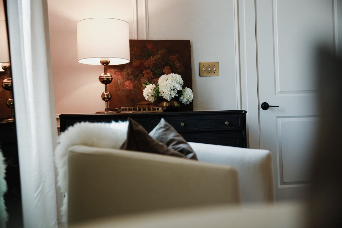 Armchair, lamp and fresh flowers in a suite